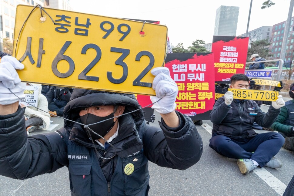 화물연대 조합원들이 12월7일 서울 여의도 국회 앞에서 자신의 차량 번호판을 들어보이며 ‘안전운임제’를 외치고 있다.