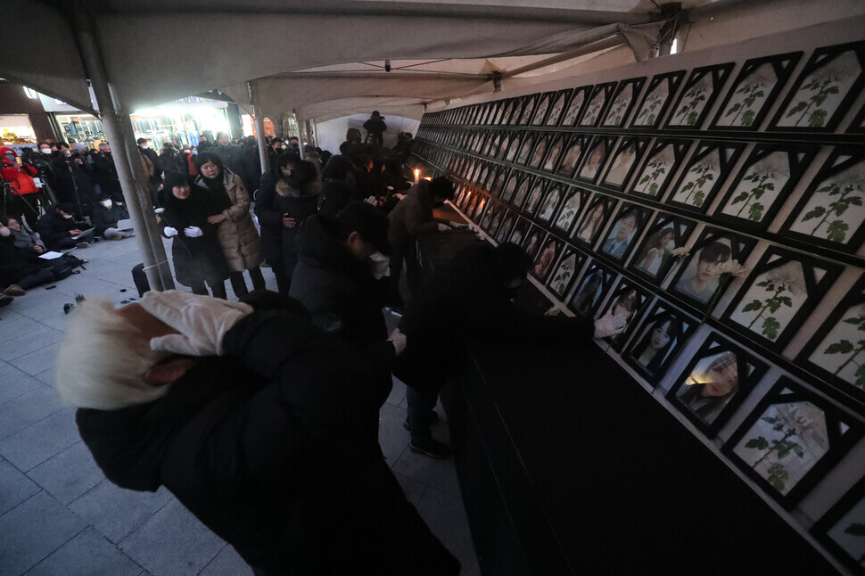 Family members of those who died in the crowd crush in Itaewon on Oct. 29 sob at a memorial altar for the deceased set up near Noksapyeong Station in Seoul on Dec. 14. (Kim Chang-kwang/The Hankyoreh)