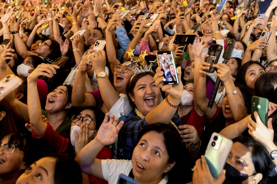 2023년을 1분여 앞둔 2022년 12월31일 밤, 필리핀 마닐라 신도심 케손시티에서 새해 축하 행사 참가자들이 일제히 휴대전화를 들어 자신과 주위를 비추며 환호하고 있다.