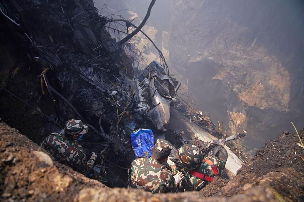 Rescuers work at the site of the crash in Pokhara, Nepal, on Jan. 15. (AFP/Yonhap)