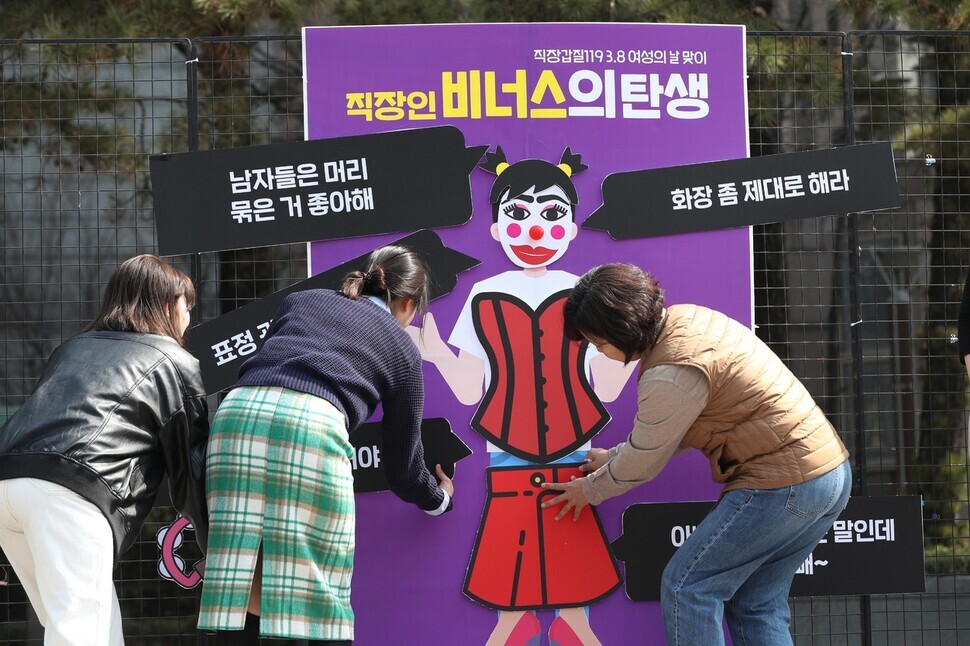 Activists with Gabjil 119, along with labor attorneys and legal professionals, stage a protest performance of look-based workplace harassment by dressing a doll in stereotypes that women often face in the office. (Kim Bong-gyu/The Hankyoreh)