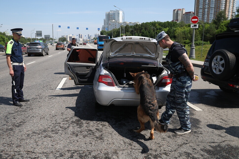 On June 25, one day after the rebellion by the mercenary Wagner Group, police in Moscow use a canine to search a vehicle. (TASS/Yonhap)