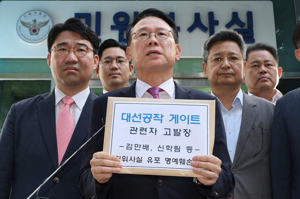 Yoon Do-hyun, the chair of the People Power Party’s special committee on media policy, and Kim Jang-kyom, the chair of the ruling party’s special committee on preventing “fake news” and rumors, are joined by other lawmakers as they announced their decision to file a complaint at the National Police Agency against Kim Man-bae, Shin Hak-lim, and journalists who reported on their allegedly faked interview. (Yonhap)