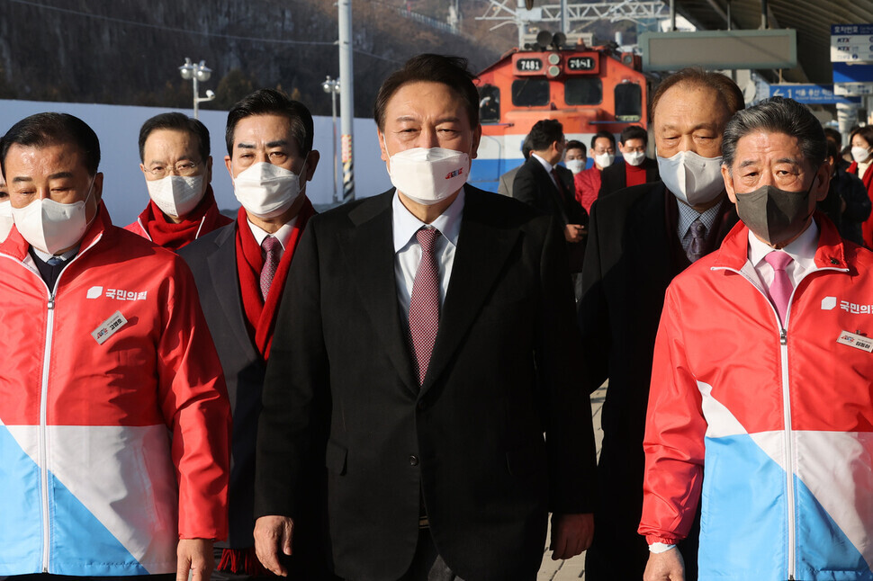 Yoon Suk-yeol is flanked by members of the People Power Party while on the campaign trail in February 2022. (Yonhap)