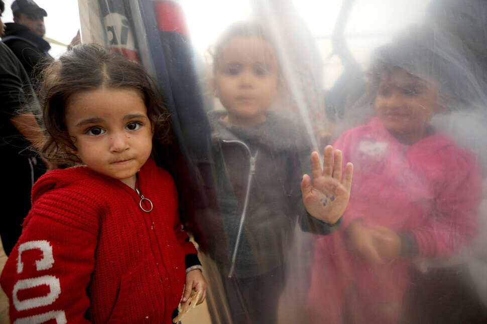 Palestinian children gaze into the camera at a shelter in Rafah, near Gaza’s southern border with Egypt, after fleeing war, on Dec. 5. (UPI/Yonhap)