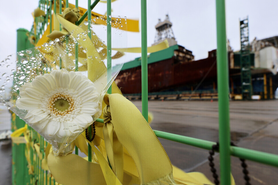 Yellow ribbons and mourning flowers adorn a fence at the harbor in Mokpo where the hull of the Sewol ferry is preserved on April 15, 2024, one day before the 10-year anniversary of the ship’s tragic sinking. (Yonhap)