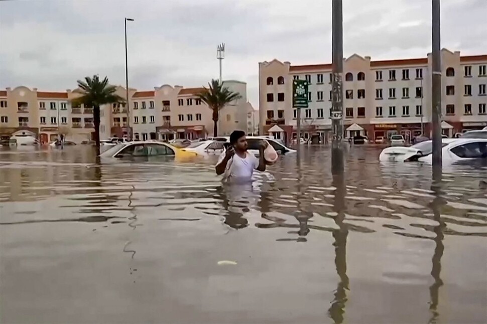 2024년 4월16일 기록적인 폭우가 쏟아진 아랍에미리트 최대 도시 두바이에서 한 남성이 침수된 거리를 지나고 있다. AFP 연합뉴스