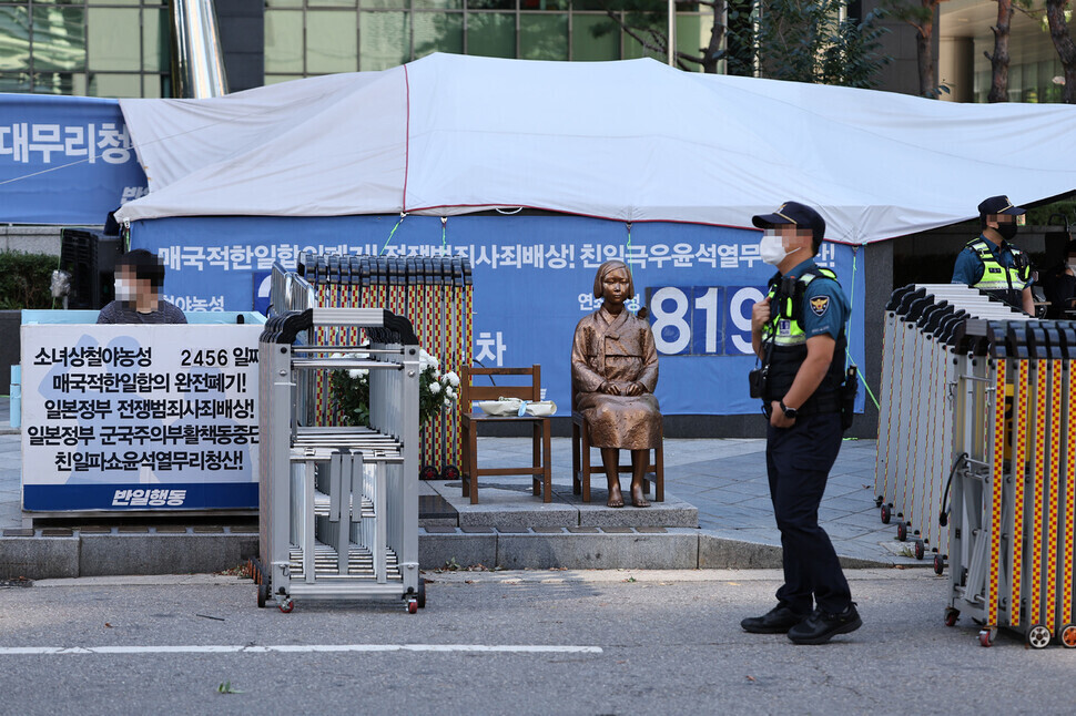 Police stand guard around a Statue of Peace representing victims of imperial Japan’s system of sexual slavery outside the former Japanese Embassy in Seoul. (Yonhap)