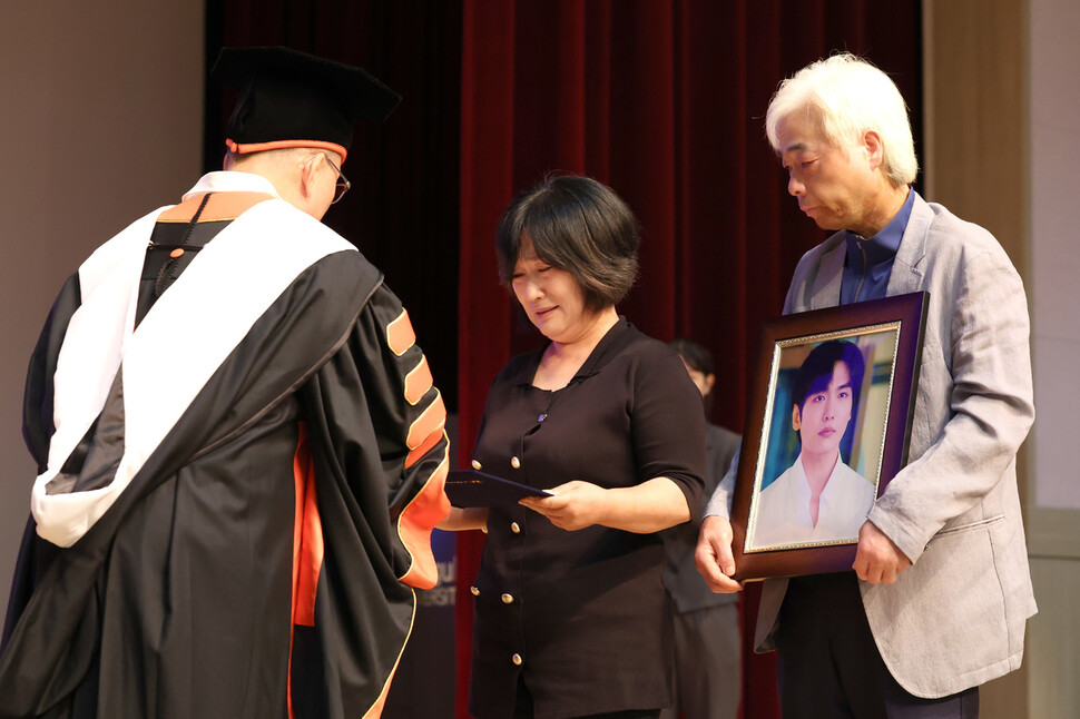 이태원 참사 희생자 이지한씨의 어머니 조미은(왼쪽)씨와 아버지 이종철씨가 22일 오전 서울 중구 동국대학교에서 열린 학위수여식에 참석해 아들을 대신해 명예 졸업장을 받고 있다. 김영원 기자 forever@hani.co.kr