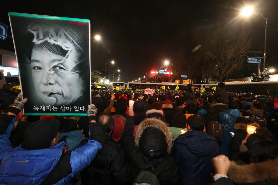 박근혜 대통령의 구속수사를 촉구하는 시민들이 2016년 11월26일 밤 서울 종로구 청운동 청와대 들머리에서 ‘박정희 전 대통령과 박근혜 대통령의 얼굴을 합성한 사진’을 들고 있다.