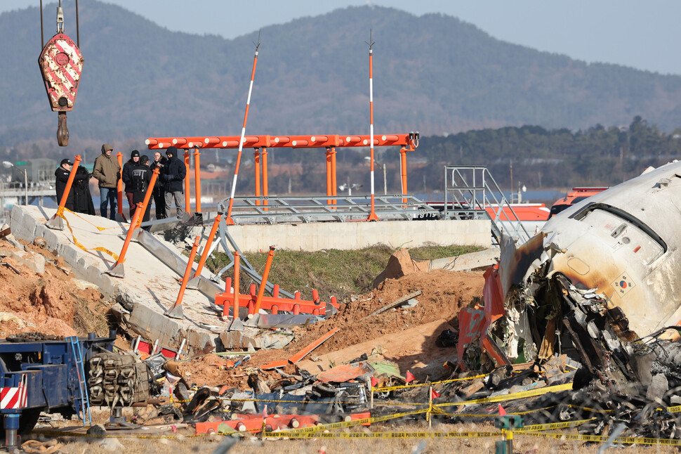 2024년 12월31일 전남 무안국제공항 ‘제주항공 참사’ 현장에서 미국 연방교통안전위원회(NTSB) 관계자들을 비롯한 한미합동조사단이 사고 여객기 기체와 방위각 제공시설이 설치됐던 콘크리트 구조물 등을 살펴보고 있다. 한겨레 김영원 기자