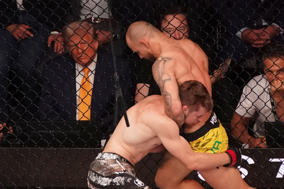 2025년 4월12일(현지시각) 미국 플로리다주 마이애미 카세야 센터에서 열린 UFC 314에서 제앙 시우바(오른쪽)와 브라이스 미첼(왼쪽)이 경기를 벌이는 장면을 도널드 트럼프 미국 대통령과 일론 머스크 테슬라 최고경영자(CEO)가 관전하고 있다. REUTERS