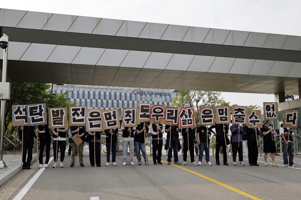 석탄화력발전소 비정규직 노동자들이 2025년 5월31일 오후 ‘공공재생에너지 확대! 발전노동자 총고용 보장! 정의로운 전환을 위한 5·21 노동자·시민 대행진’을 마친 뒤 충남 태안군 태안읍 평천리 한국서부발전 본사 앞에서 고용보장을 요구하는 손팻말을 들고 있다. 김명진 기자