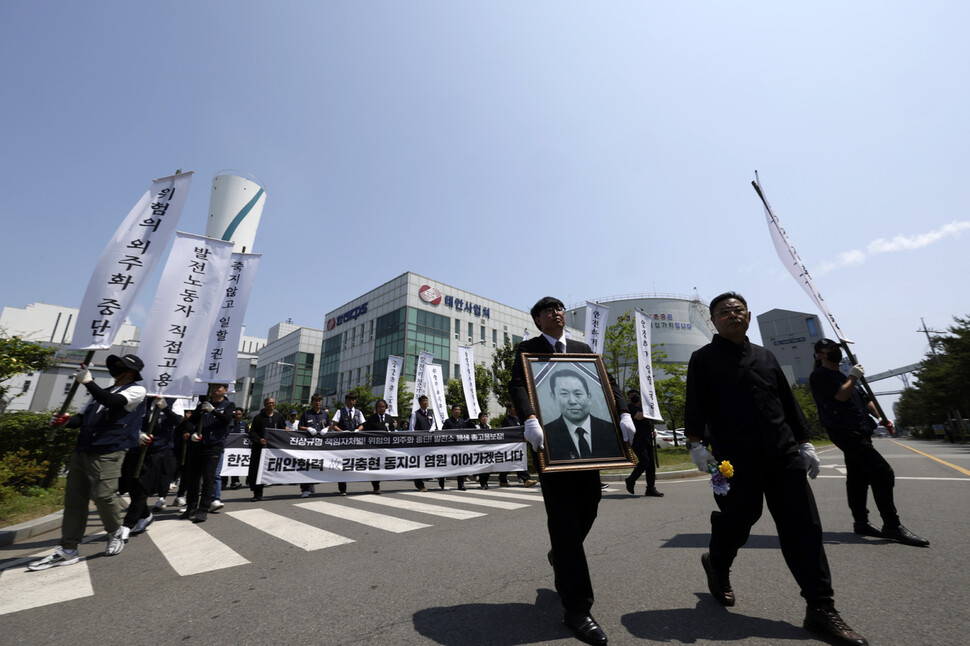 고인의 영정을 든 동료들과 영결식 참석자들이 김충현씨가 일하던 장소를 빠져나가고 있다.