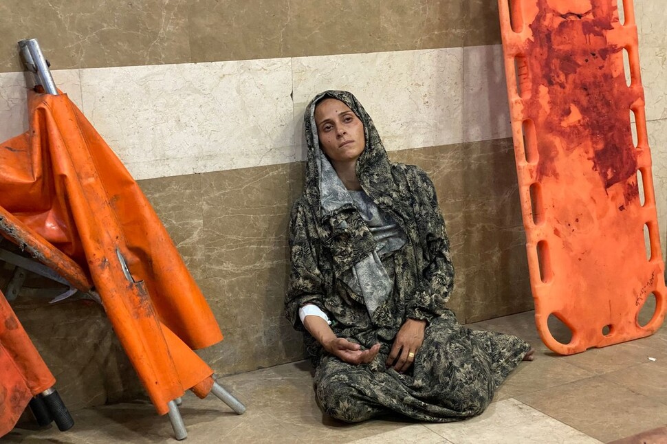 2025년 7월8일 팔레스타인 땅 가자지구 남부 칸유니스의 나세르병원에서 이스라엘의 피란민촌 공습으로 다친 여성이 망연한 표정으로 앉아 있다. AFP 연합뉴스