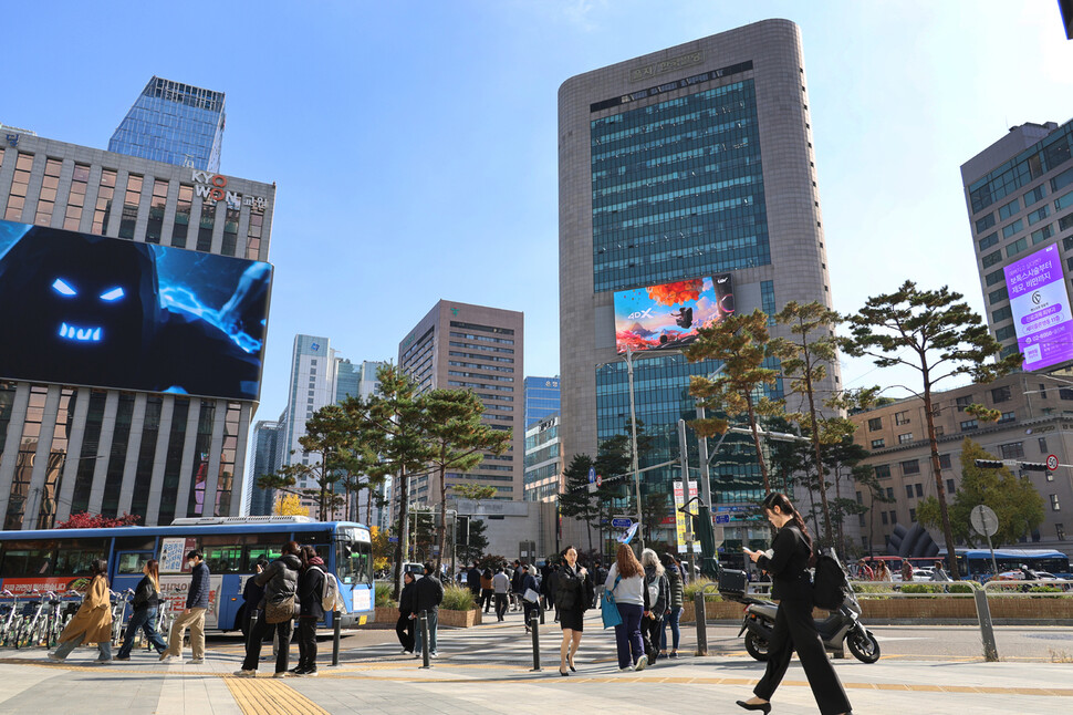 대형 전광판이 늘어선 서울 을지로 거리를 시민들이 걷고 있다.