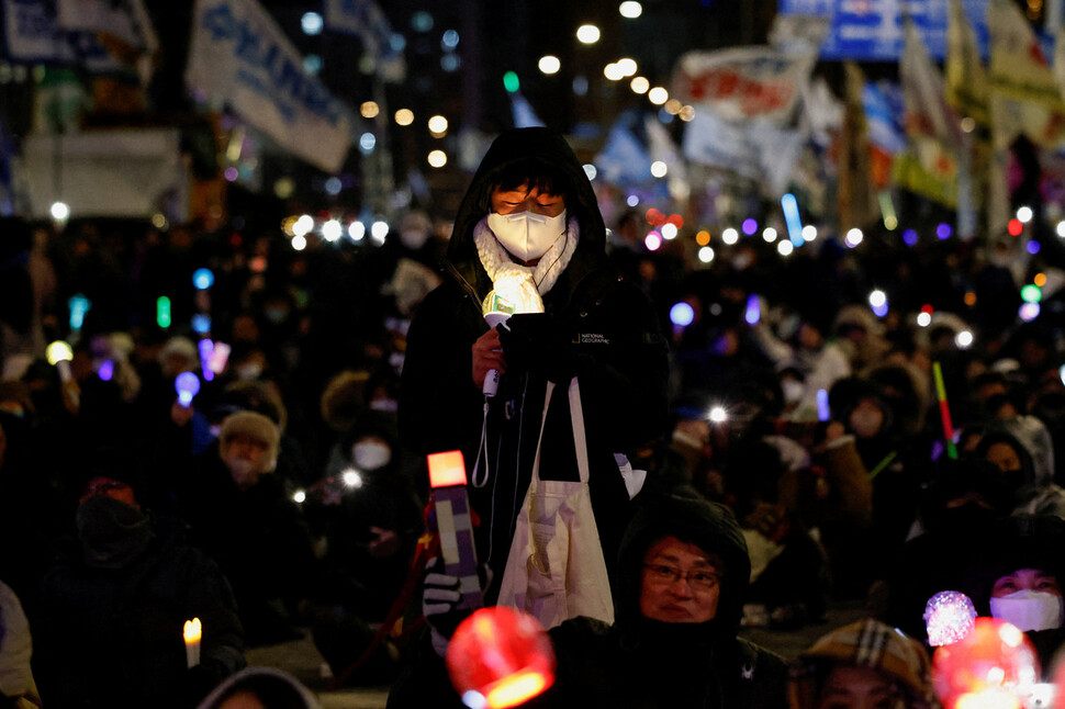 2025년 12월3일 저녁 서울 여의도 국회 앞에서 열린 ‘12·3 내란·외환 청산과 종식, 사회대개혁 시민대행진’에 참여한 시민들이 응원봉을 들고 있다. REUTERS
