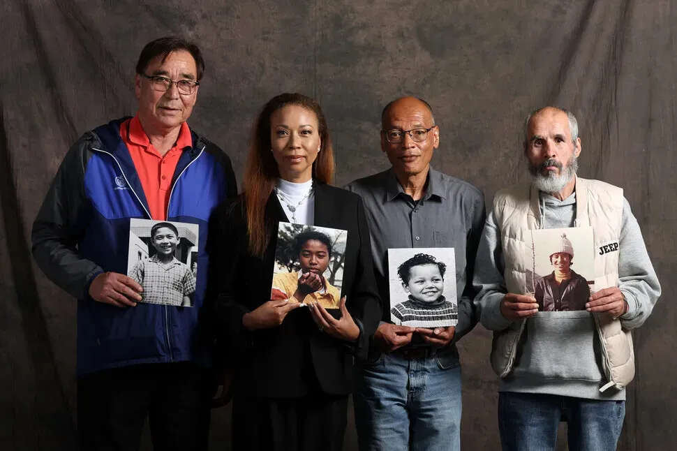 Cho Young-il, Meeky Woo Flippen, Simon Hokwerda, and Oh Jae-gyeong hold up photos of themselves taken around the time that they were sent abroad for adoption as children. (Kim Young-won/Hankyoreh)