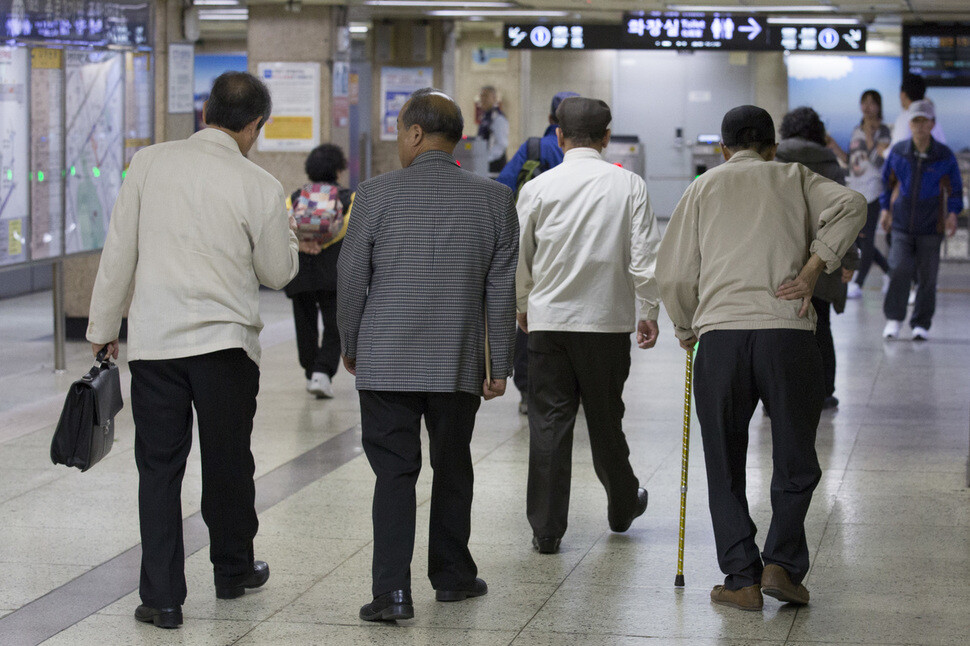 Elderly men walk through a subway station in Seoul. On Seoul’s transit system