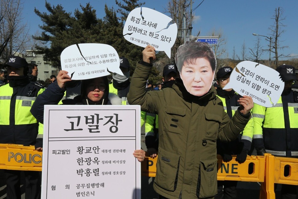 Members of the Labor Party wear masks depicting President Park Geun-hye during a performance condemning the Blue House
