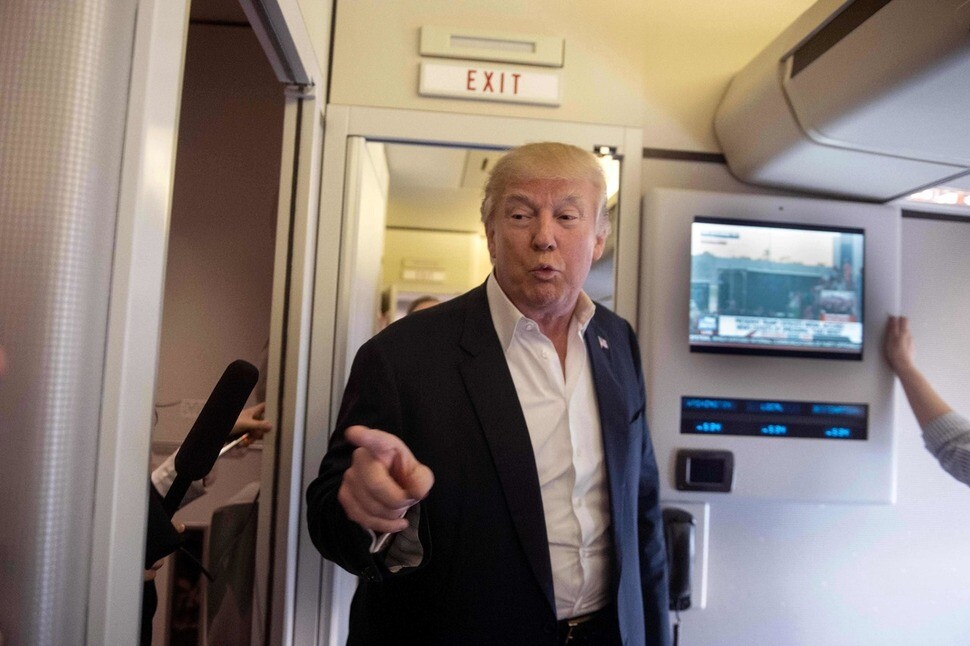 US President Donald Trump talks to reporters aboard a plane headed for Florida