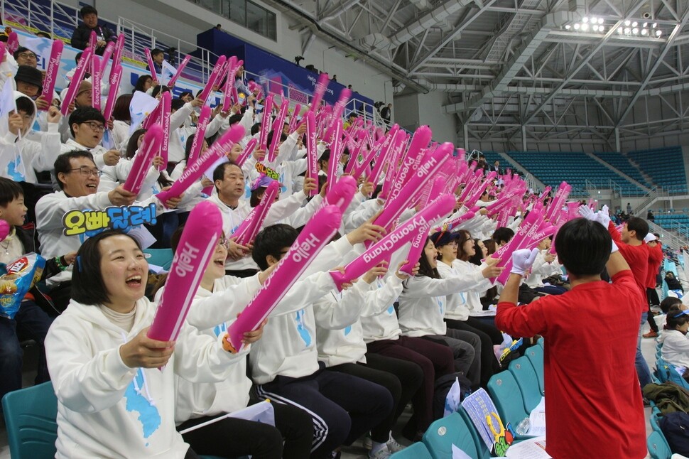 South Koreans wave flags showing a unified Korean peninsula while cheering the North Korean women’s national team