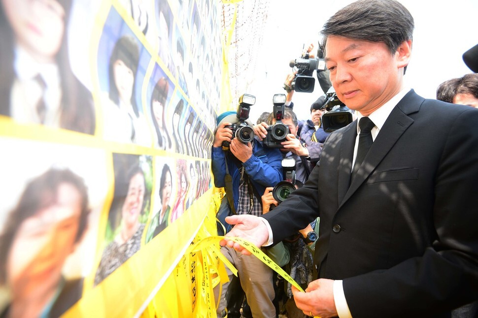 People’s Party presidential candidate Ahn Cheol-soo ties a commemorative yellow ribbon near the Sewol ferry