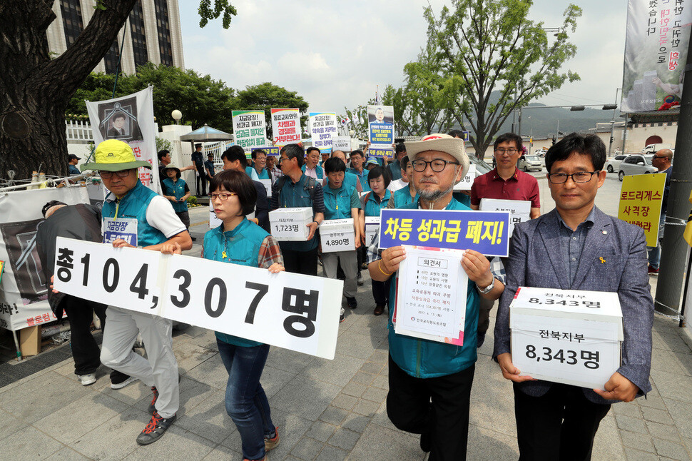 Participants in a signature campaign to abolish government plans for a performance-based pay system march after a press conference outside the Central Government Complex in Seoul