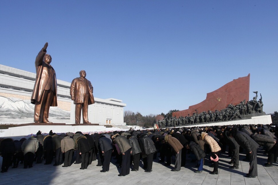 North Korean citizens observe the sixth anniversary of former leader Kim Jong-il’s death by bowing before the statues of Kim and his father Kim Il-sung at Mansudae Hill in Pyongyang on Dec. 17. North Korean media reported that party leaders such as Vice Marshal Choi Ryong-hae