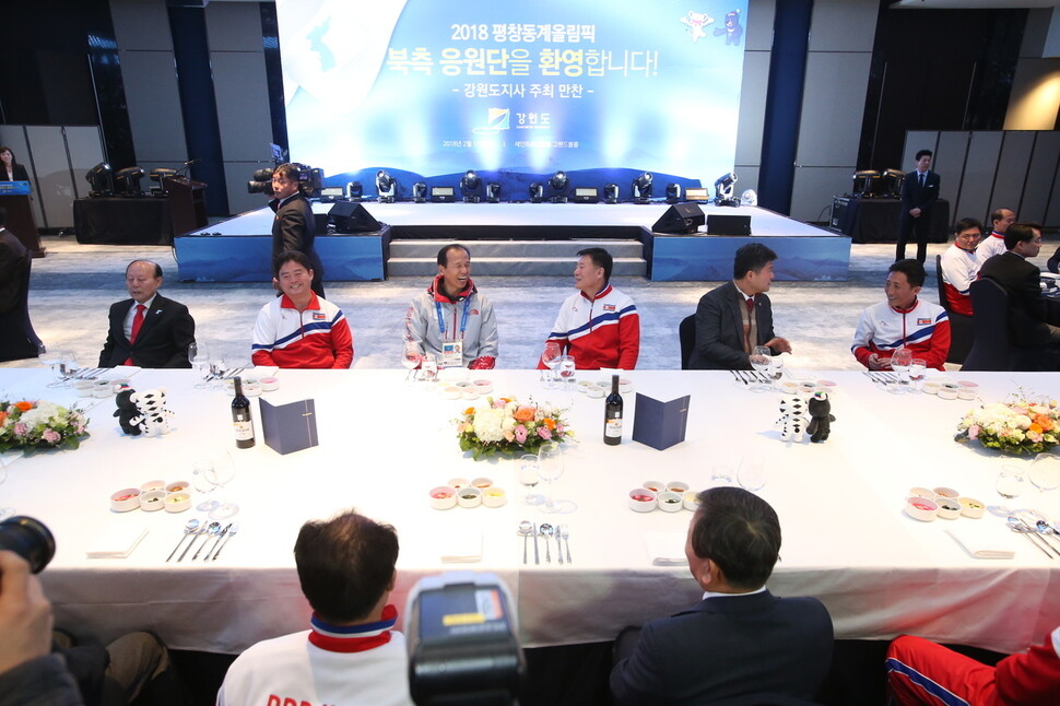 Gangwon Governor Choi Moon-soon shares a laugh with the director of the North Korean cheerleading squad