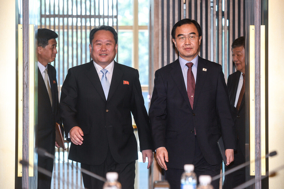 South Korea’s Minister of Unification Cho Myung-gyon (right) and chairman of North Korea‘s Committee for Peaceful Reunification Ri Son-gwon enter the meeting room of the House of Peace on the South Korean side of Panmunjeom for the high-level inter-Korean talks on June 1. (joint photo pool)