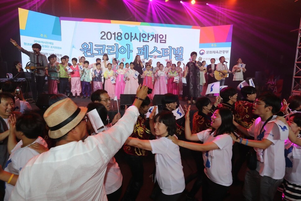 Members of the One Korea Joint Cheering squad wave Korean Peninsula flags during the 2018 Asian Games One Korea Festival on Aug. 19 in Jakarta