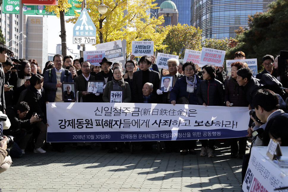 An association of supporters and family members of South Korean victims of forced mobilization and labor under the Japanese colonial occupation celebrate the South Korean Supreme Court’s ruling that Nippon and Sumitomo Metal must pay reparations to the victims on Oct. 30 in Seoul. (Kim Myoung-jin