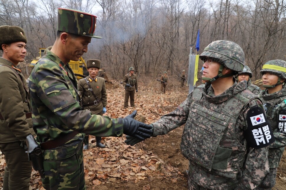 South and North Korean military officials and soldiers greet each other at military roads connecting South and North Korea through the DMZ
