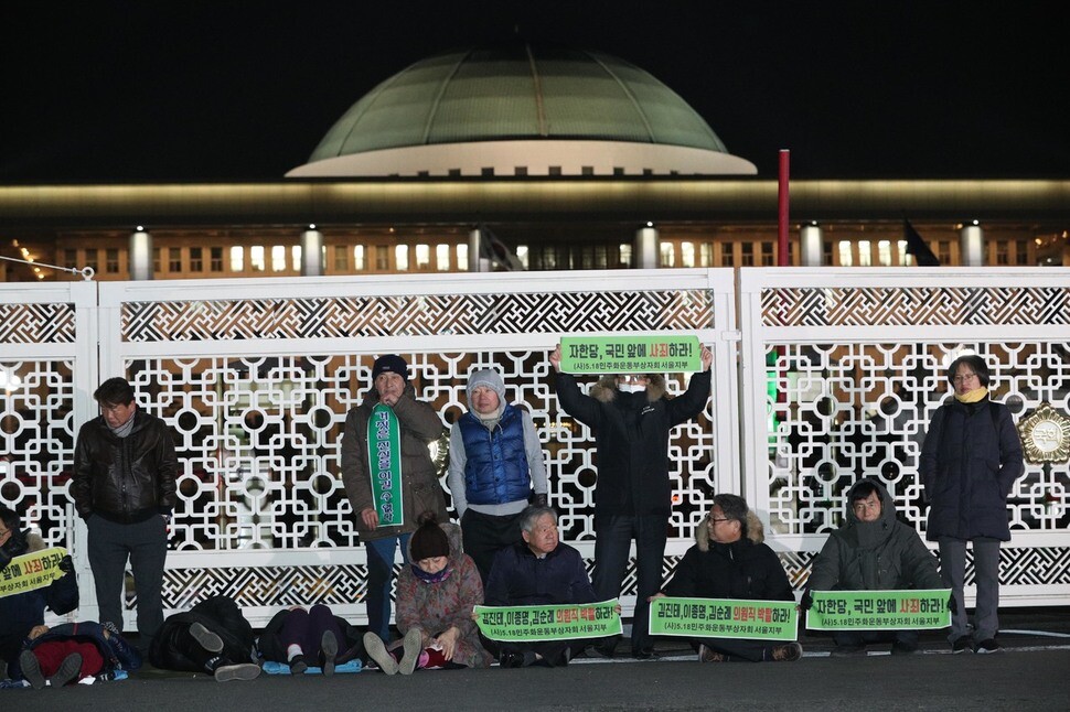 Civic demonstrators call for legal punishments for defaming or distorting the events of the Gwangju Democratization Movement in front of the National Assembly in Seoul on Feb. 11. (Kim Bong-gyu