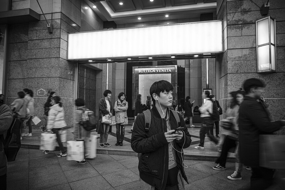 헤이든이 퇴근 뒤 서울 중구 명동에서 버스를 기다리고 있다. 그는 영어책 출판사에서 일한다.