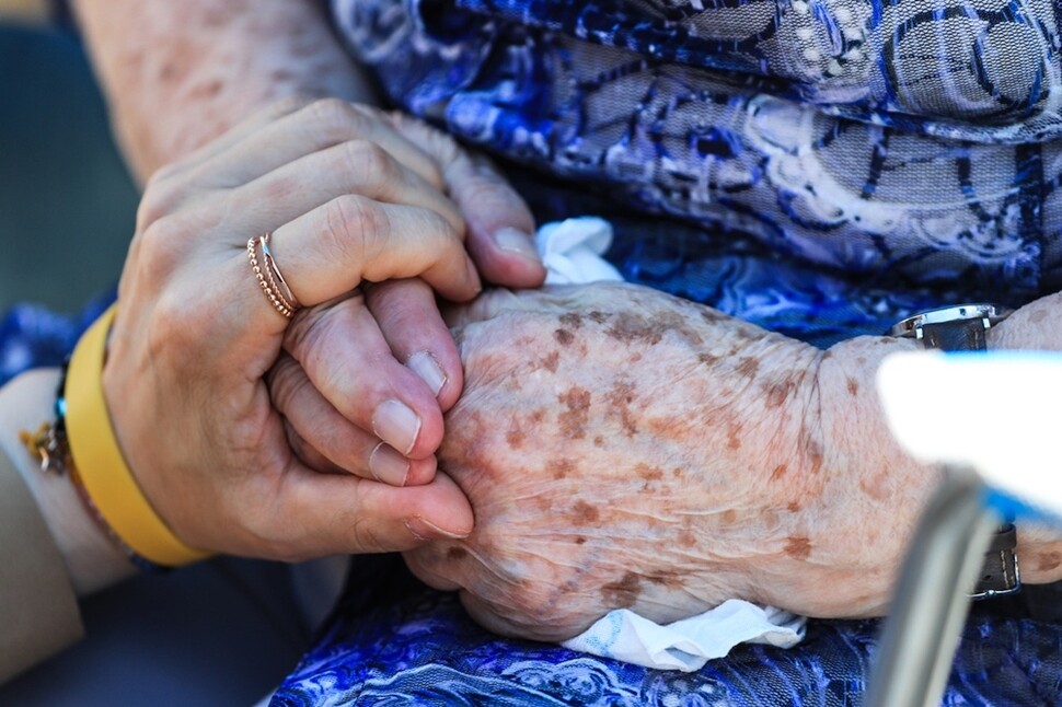 수요집회에 참가한 한 시민이 함께 자리한 일본군 성노예제 피해자 길원옥 할머니의 손을 잡고 있다.