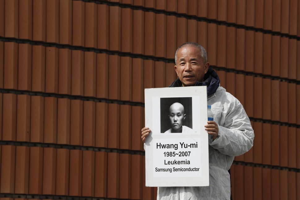 Hwang Sang-ki, president of watchdog group Banollim and father of Hwang Yu-mi, who died after contracting leukemia while working at a Samsung Electronics semiconductor factory, holds up a photo of his late daughter in front of Leeum Samsung Museum of Art in Seoul on Mar. 6, 2017. (Lee Jeong-a, staff photographer)