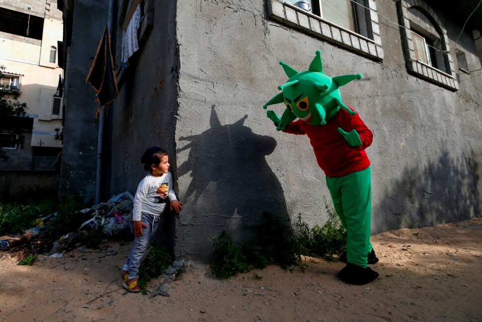 4월20일 팔레스타인 가자지구에서 코로나바이러스로 분장한 남성이 어린이와 놀아주고 있어요. AFP 연합뉴스
