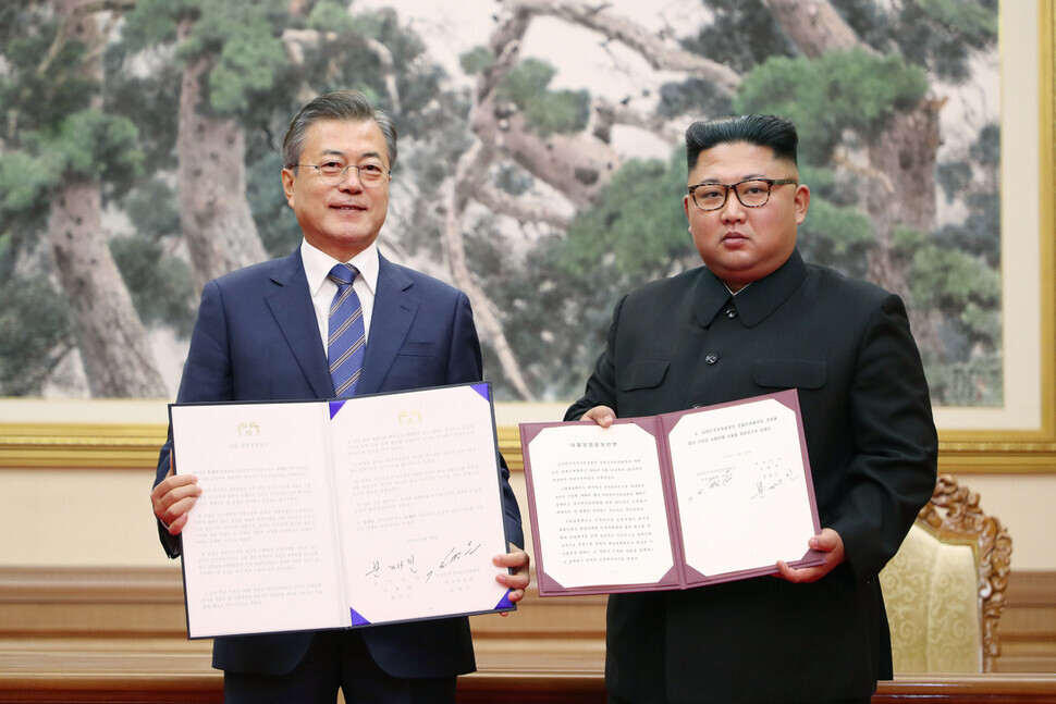 South Korean President Moon Jae-in and North Korean leader Kim Jong-un hold up the Pyongyang Joint Statement after signing it at the Paekhwawon State Guest House in Pyongyang on Sept. 19, 2018. (photo pool)