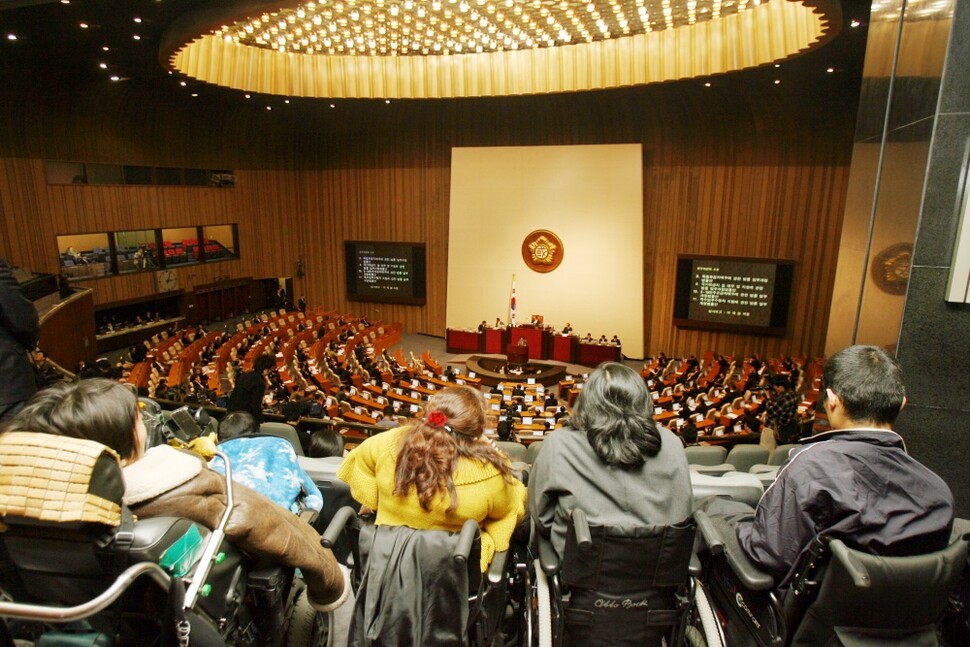 2007년 2월 휠체어를 탄 장애인들이 국회 본회의장에서 장애인차별금지법안 처리를 기다리고 있다. 연합뉴스