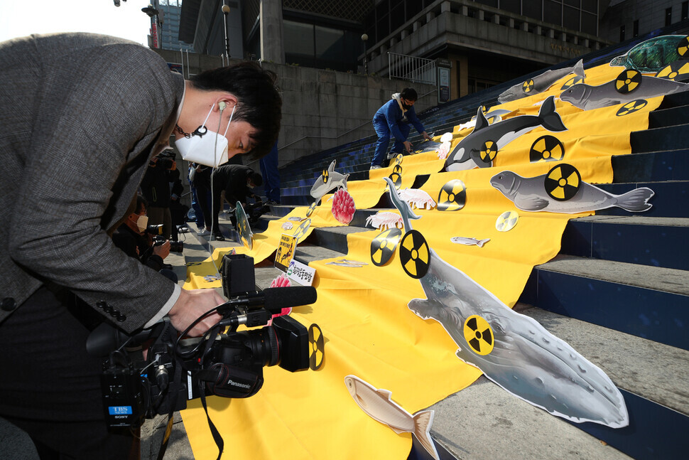 Reporters from Japan’s TBS cover the demonstration.