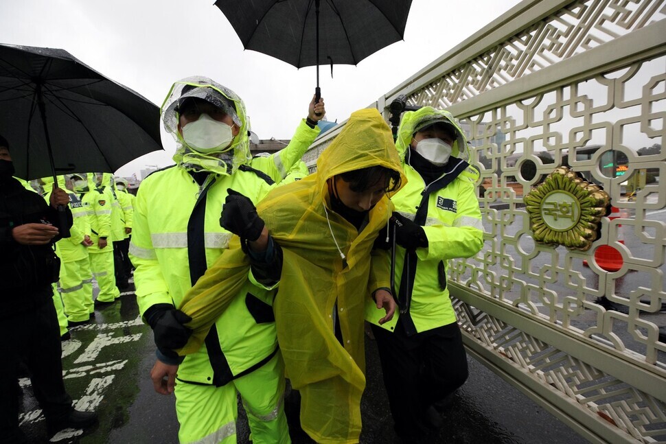 An environmental activist is escorted by the police away from the National Assembly on Nov. 19.
