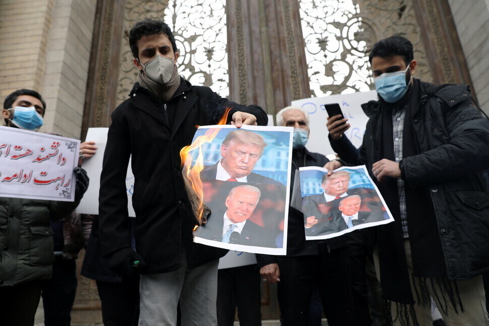 Iranians in Tehran set fire to photos of US President Donald Trump and President-elect Joe Biden to protest the assassination of Iranian nuclear scientist Mohsen Fakhrizadeh. (Reuters/Yonhap News)