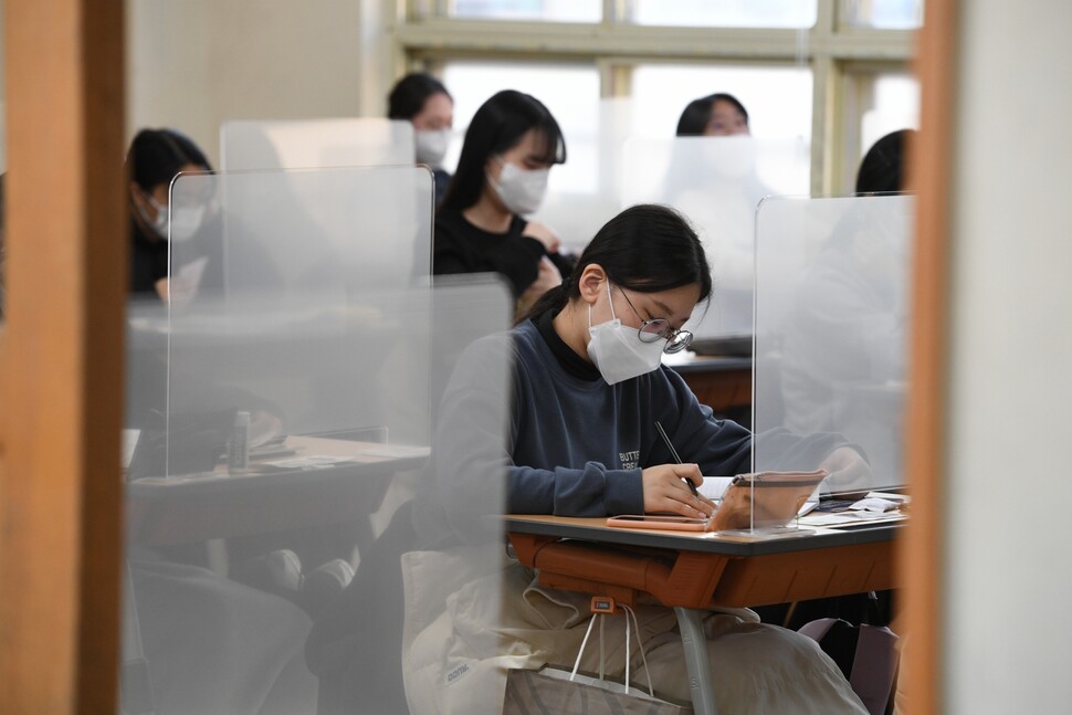 2020년 12월3일 부산의 한 고사장에서 수험생들이 아크릴 칸막이를 한 책상에서 마스크를 쓴 채 대학수학능력시험을 치르고 있다. 사진공동취재단