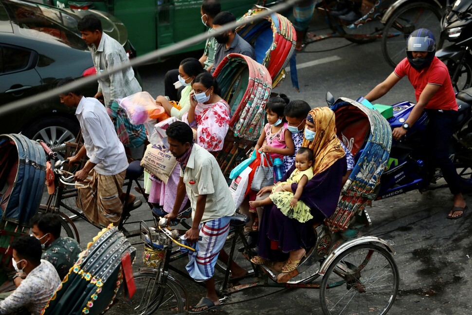 지난 11월19일(현지시각) 방글라데시 다카에서 시민들이 마스크를 쓴 채 인력거의 일종인 교통수단 릭쇼를 타고 이동하고 있다. 로이터 연합뉴스