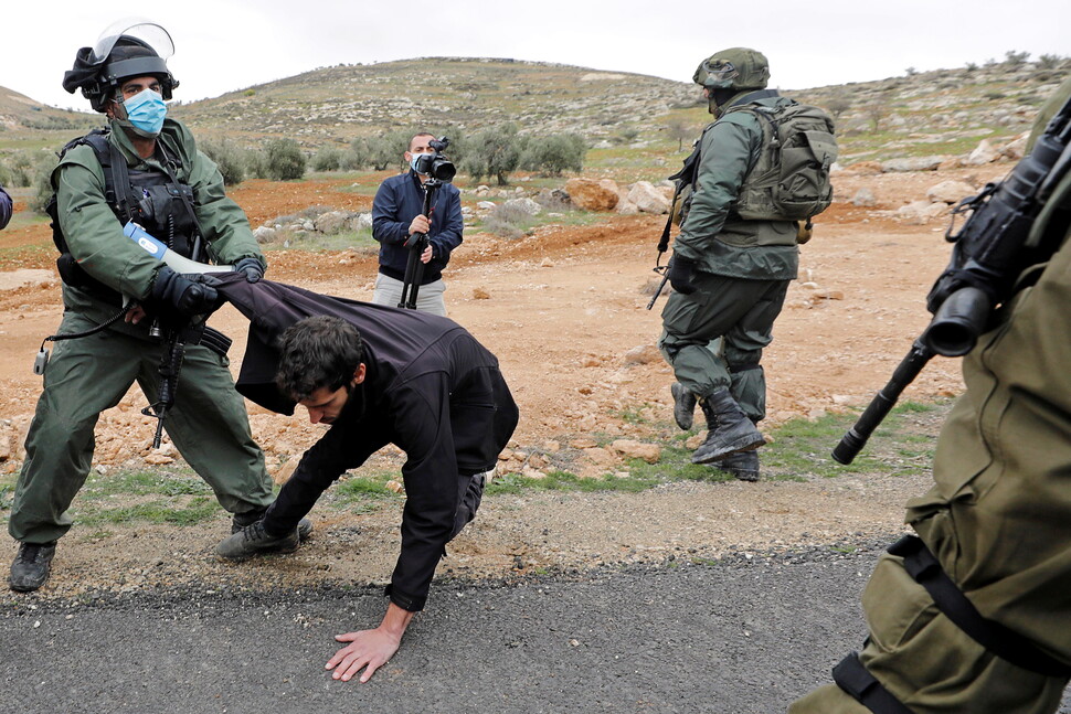 이스라엘군이 1월15일 이스라엘 점령지인 요르단강 서안의 헤브론 인근 마사페르 야타에서 이스라엘 정착촌 반대 시위를 하는 팔레스타인 시위대를 끌어당기고 있다. 로이터/무사 카와스마
