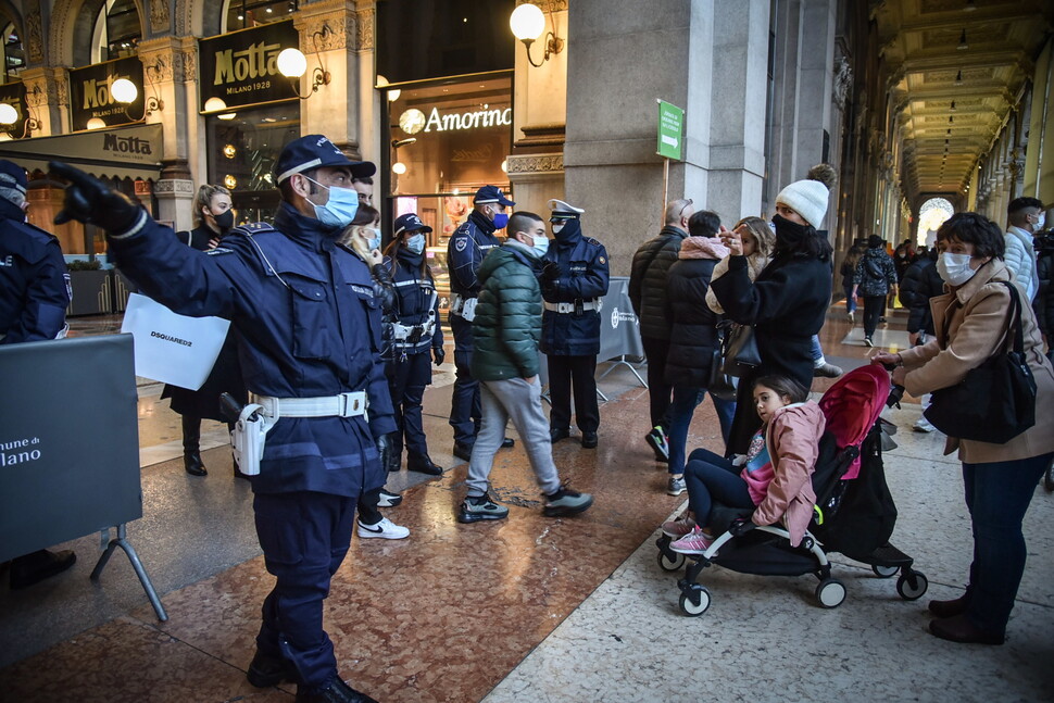 2020년 12월 이탈리아 북부 도시 밀라노 도심에 있는 쇼핑가 비토리오 에마누엘레 갤러리의 한 피자가게 입구에서 경찰이 코로나19 확산에 따른 사회적 거리 두기를 위해 입장객 흐름을 통제하고 있다. EPA 연합뉴스