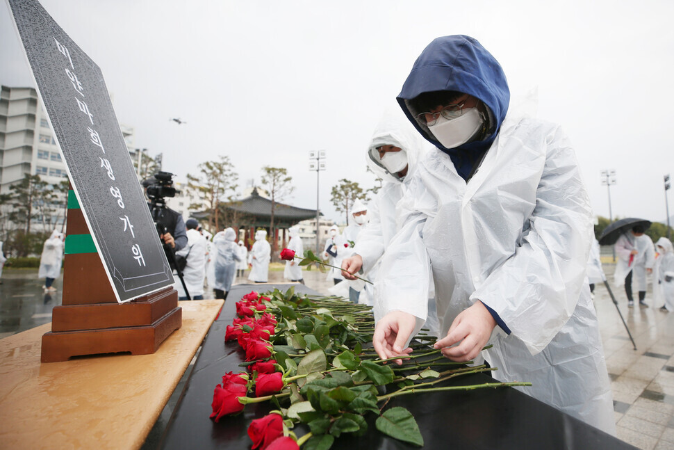 People lay down red roses to honor the victims of democracy protests in Myanmar during a memorial held in Gwangju on Saturday, in line with the Burmese custom of remembering the dead with red flowers. (Yonhap News)