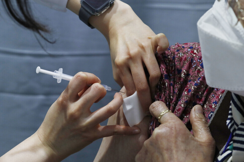 A woman receives the Pfizer COVID-19 vaccine Thursday at a vaccination center in Seoul. (Kim Hye-yun/The Hankyoreh)
